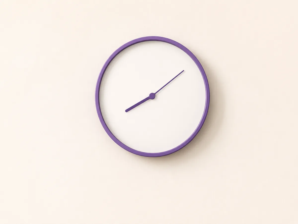 A blank-faced clock on a pale wall