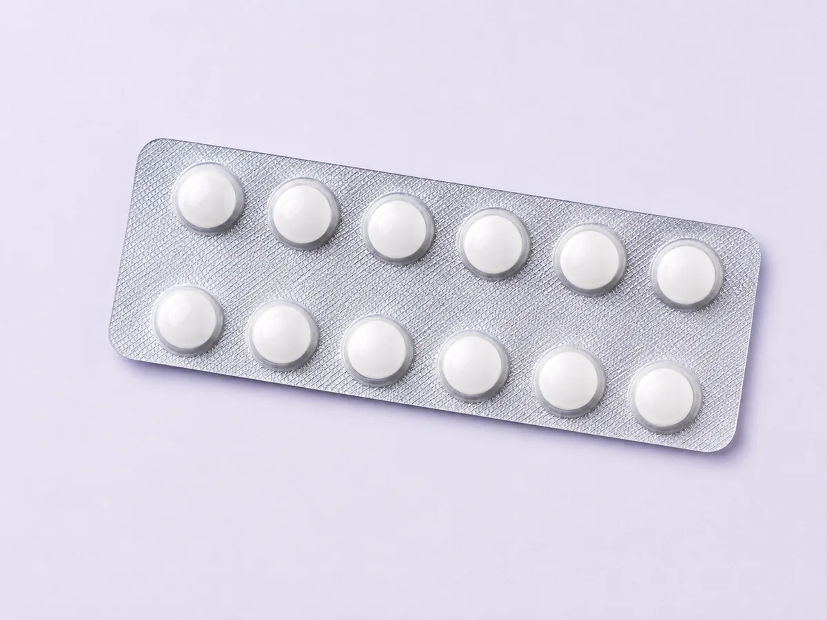 A plain tablet strip on a pale surface