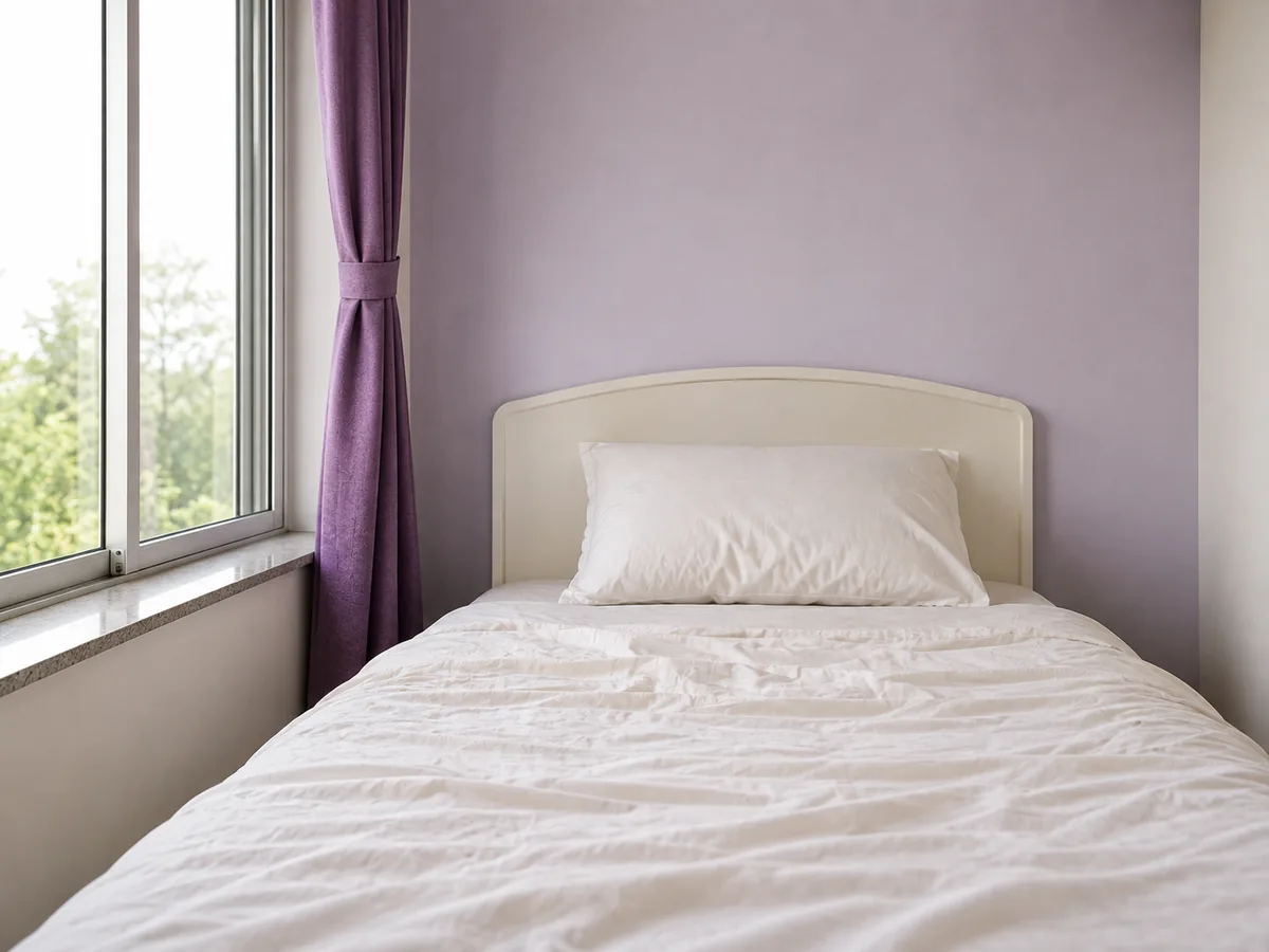 An unmade bed in flat morning light