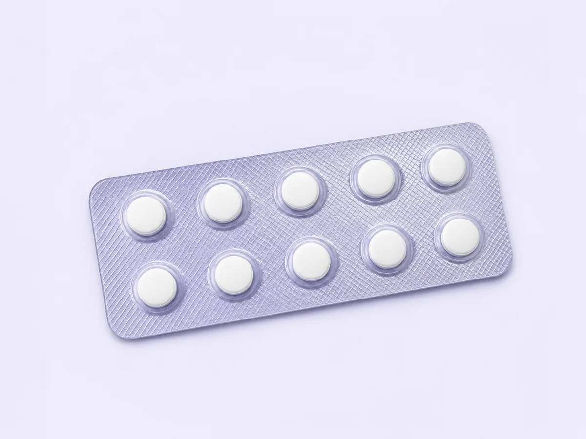 A plain tablet strip on a pale surface